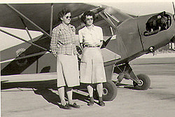Lois and Holly, flight instructors with J-3 cub.